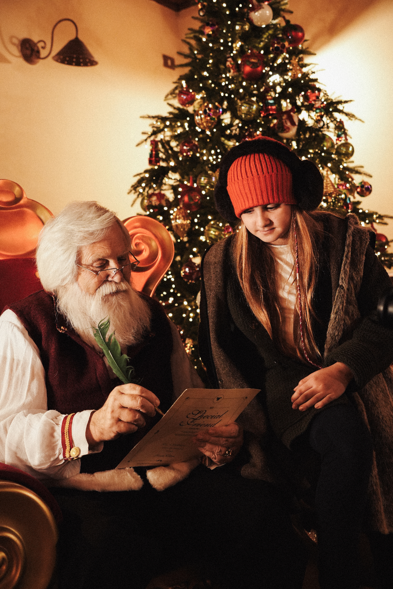 Babbo Natale e una bambina leggono insieme un libro